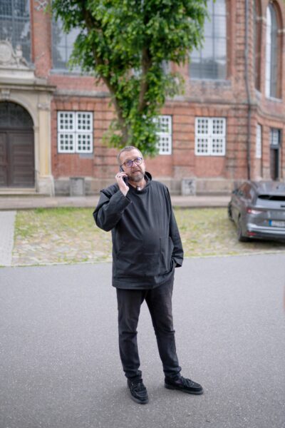 Pastor telefoniert vor Kirche