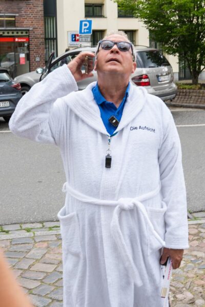 Rüdi steht vor Kirche in Wilster und telefoniert
